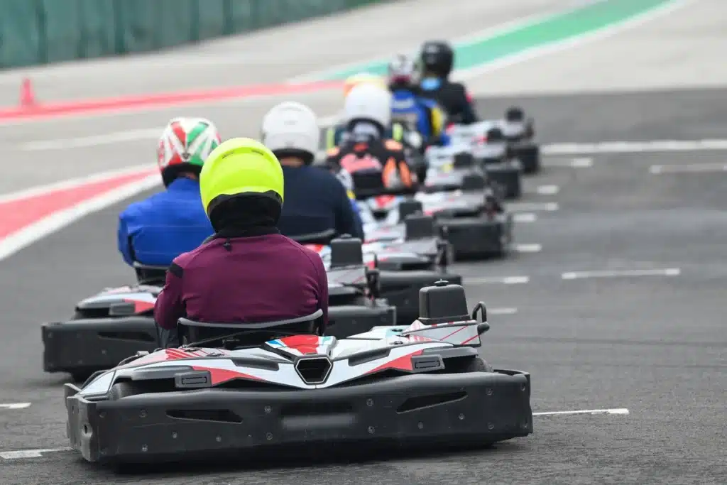 Des individus s'affrontent en karting sur une piste, illustrant l'excitation d'une course dynamique.