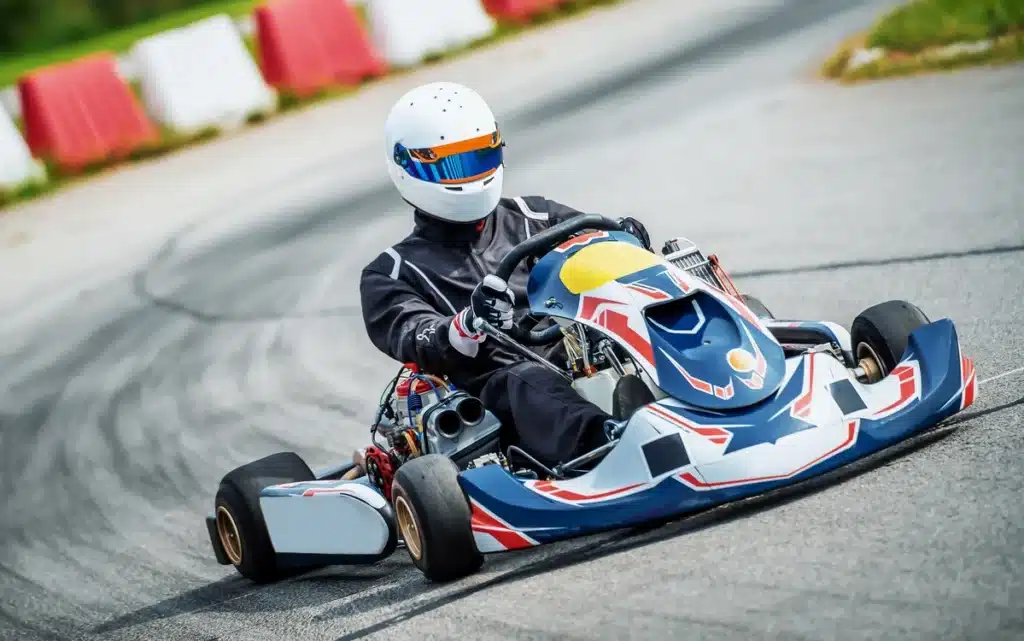 Une personne conduisant un kart sur une piste, concentrée sur la course et profitant de l'adrénaline du moment.